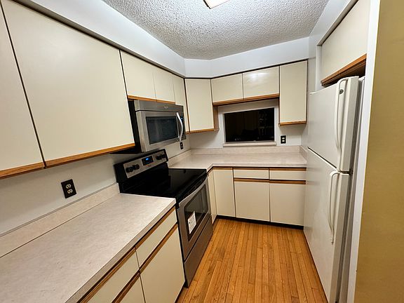 Kitchen with stainless steel microwave and range/stove (electric) ; refrigerator.