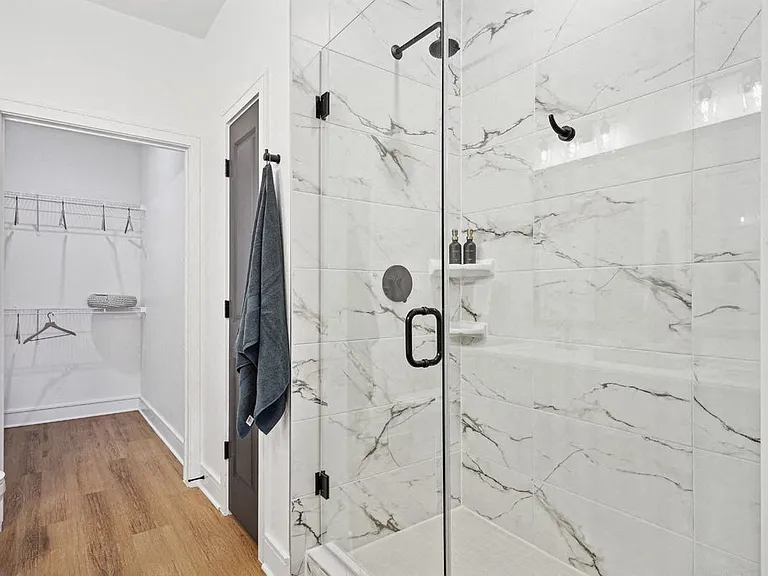 Bathroom with Quartz Countertops, Double Vanity Sinks, Walk-in Shower, and Walk-in Closet