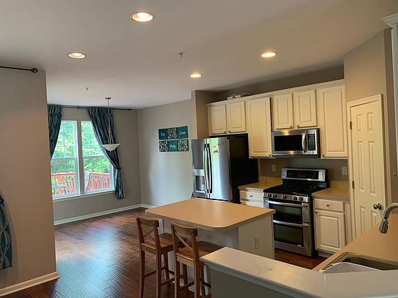 Large kitchen with dining area, island, pantry closet, & stainless steel appliances