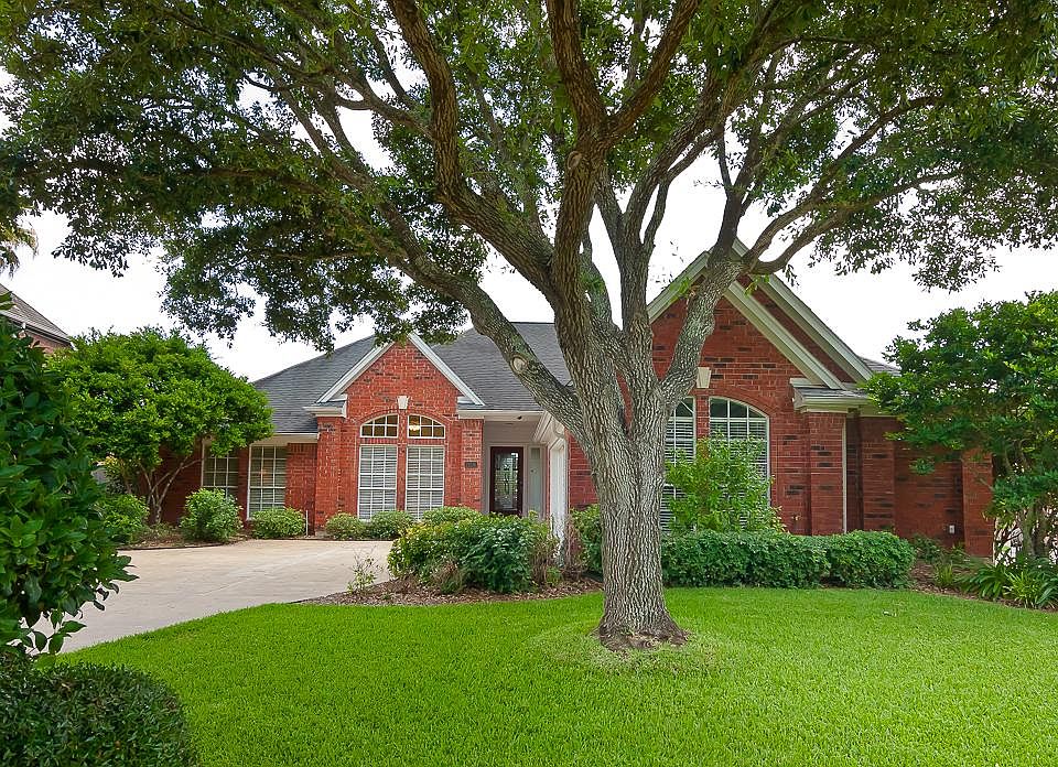 Former model home built by David Weekley featuring a covered front porch, professional landscaping w