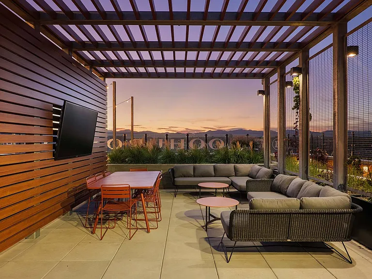 Relax in the rooftop lounge, with stunning mountain views, a stylish table, comfy couch, and a TV for ultimate enjoyment.