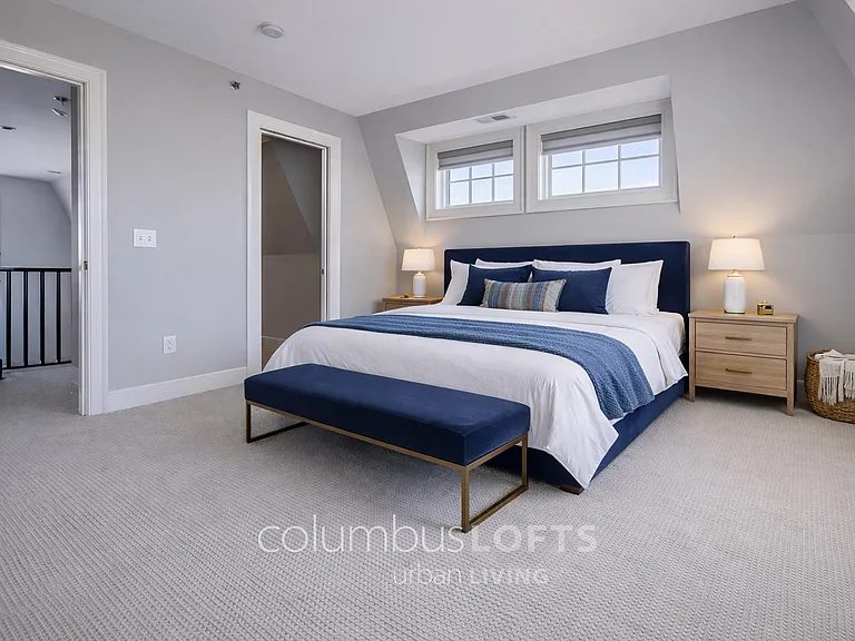 upper level bedroom 1, which has narrow walk-in closet shown to left of bed.