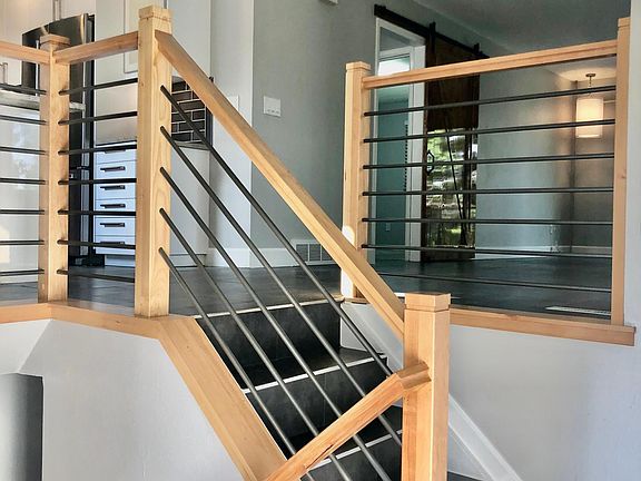 Modern alder wood stair rail make for an inviting entrance