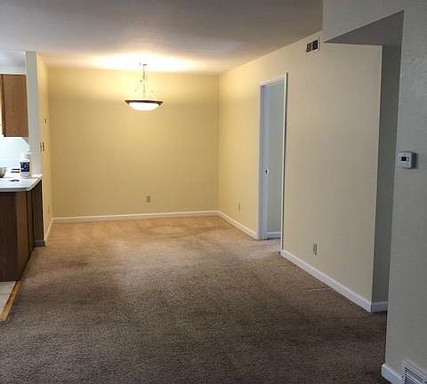 Connected dining area behind living room area with open kitchen layout