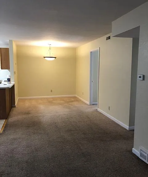 Connected dining area behind living room area with open kitchen layout