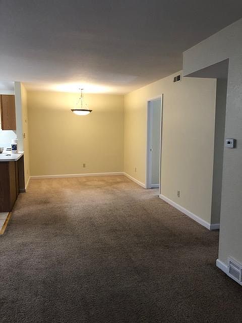 Connected dining area behind living room area with open kitchen layout