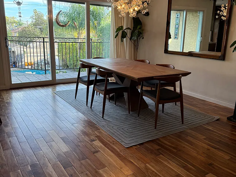 Dining area overlooking the pool and backyard. Fiddle leaf fig trees.