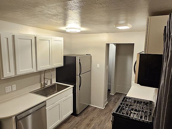 kitchen view 2 New cabinets, new counters, Farm style sink, new floors and stove, microwave and fridge