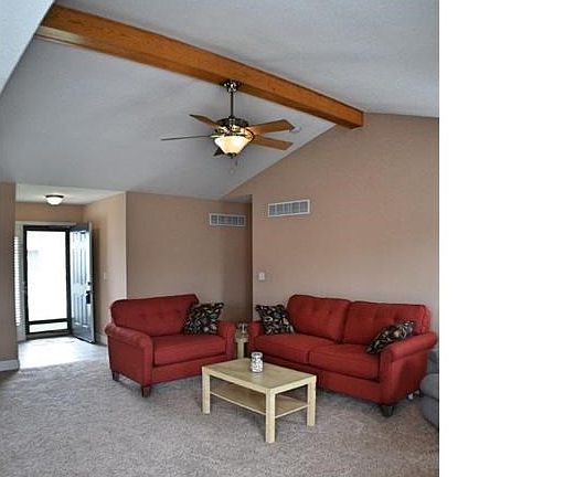 Foyer into Great Room with vaulted ceiling and decorative ceiling beam.