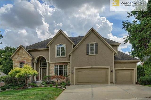 Beautifully, landscaped entrance accents stucco and stone front.