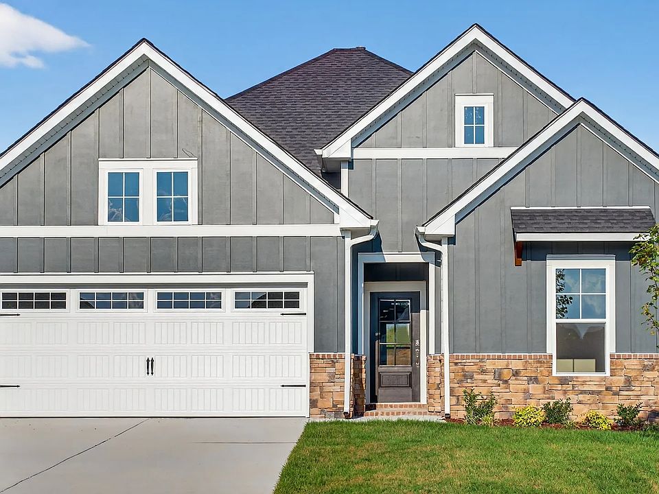 Elegant gray facade with stone details and gabled roof offers timeless luxury. Belmont, McClure Farm