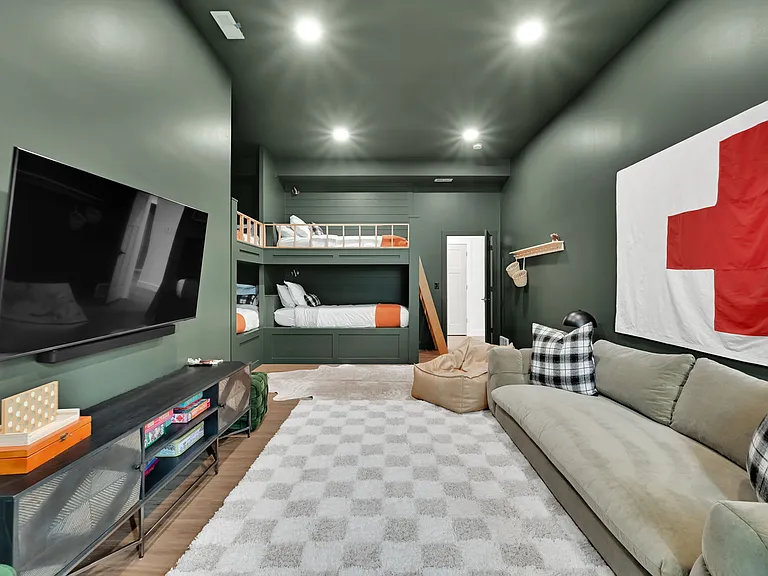 Downstairs bunk bedroom with 4 Twin LX beds and couch, games, large Smart TV and walk in closet.