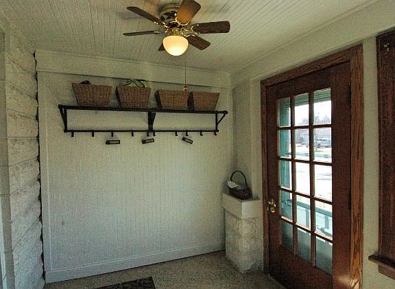 The quaint front porch has an epoxy floor covering and room to hang a few jackets.