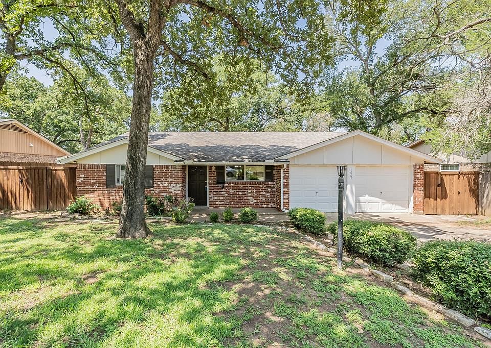 Single story home featuring a garage and a front lawn