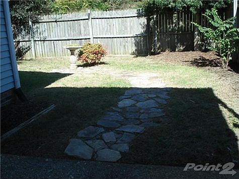 Stepping stones leading from patio to private backyard