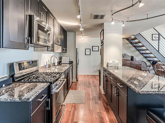 Stunning Kitchen with gleaming wood floors and granite counter tops. The very open area boasts a great view of the rest of the downstairs.