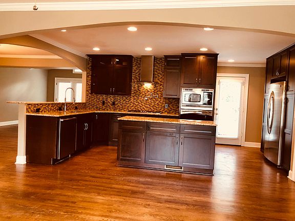 Open kitchen, stainless appliances, bar seating and industrial kitchen faucet.