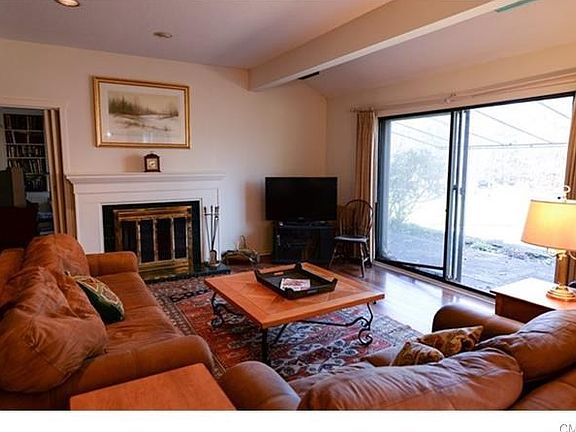 Living room with wood burning fireplace and sliders to patio.
