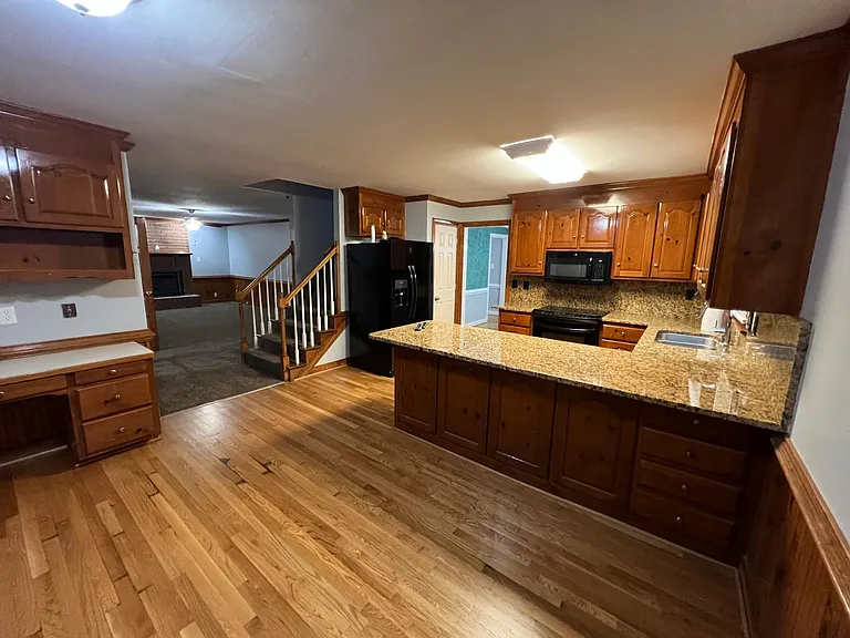 Photo of kitchen looking at stairwell and family room.