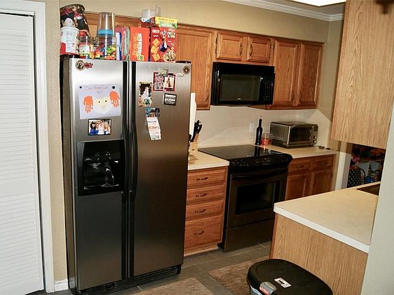 Kitchen with upgraded cabinets.  Pantry on left.  Stainless steel refrigerator included with the sale.