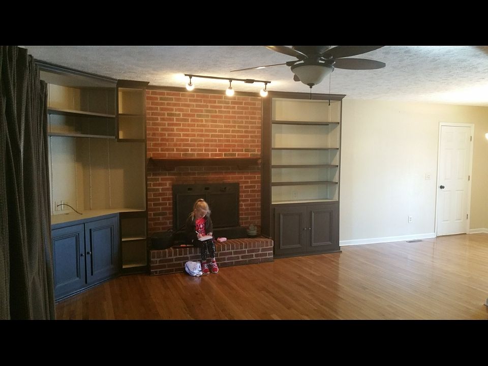 Living area with built in cabinets and open to dining and kitchen areas
