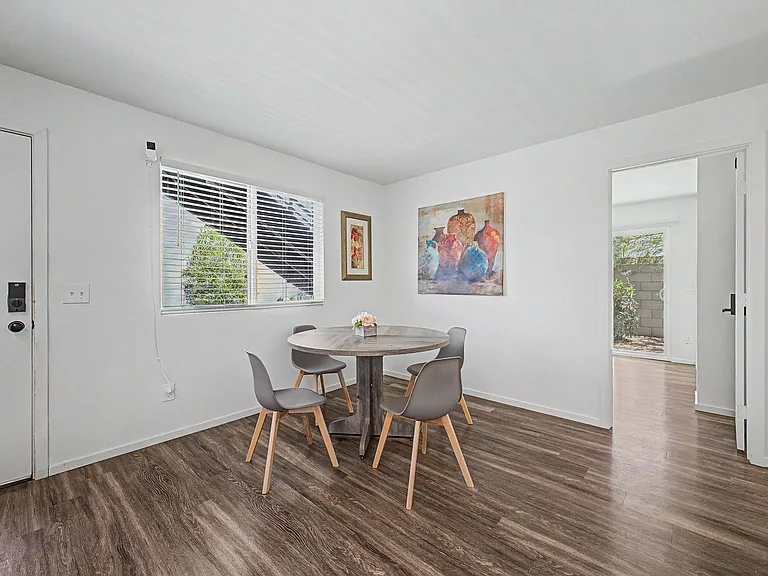 Dedicated dining area with a round table, wood-look flooring, and a large window, plus easy access to the patio.