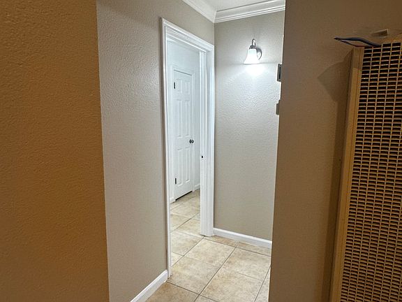 Living room with wall heater, hallway to bed and bath