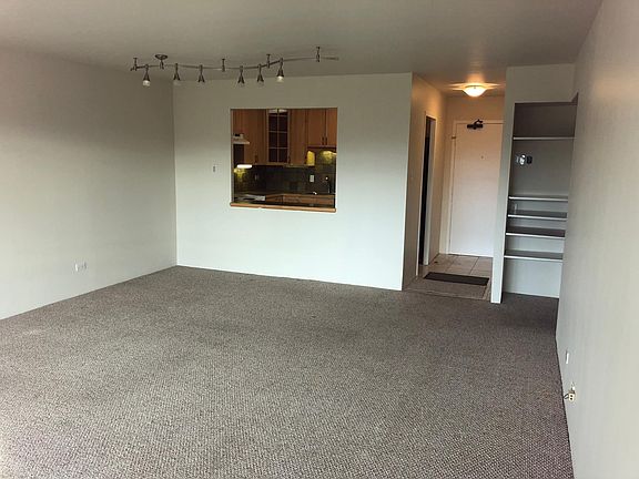 Living room looking towards kitchen and condo entry.