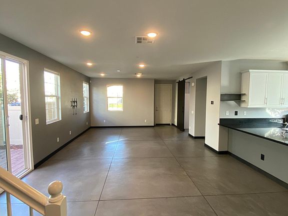 Living room as well as dining area. Kitchen on the right, stairs on the left