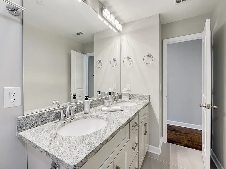 The second bathroom features a spa-like double vanity and a bathtub.