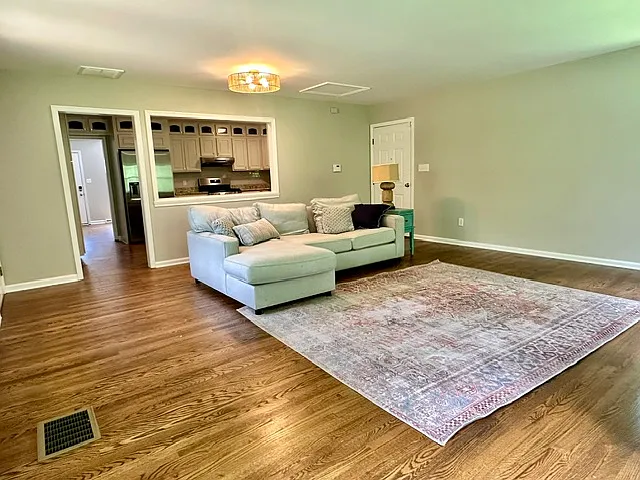 Large sunny living room off of the kitchen with a door that leads to huge deck.
