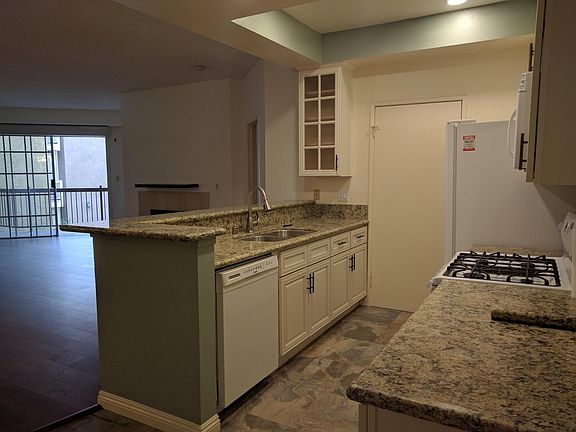 Kitchen from the breakfast nook which has cupboards for dry grocery items.