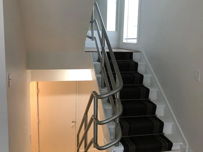 View of stairway leading down to entry level and up to mid-level.