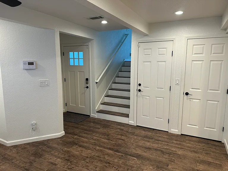 View from kitchen of front door, garage door (middle), and bathroom & laundry room (right).