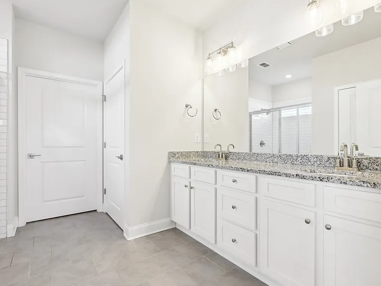 Primary bathroom with double vanity, walk-in shower and walk-in closet.