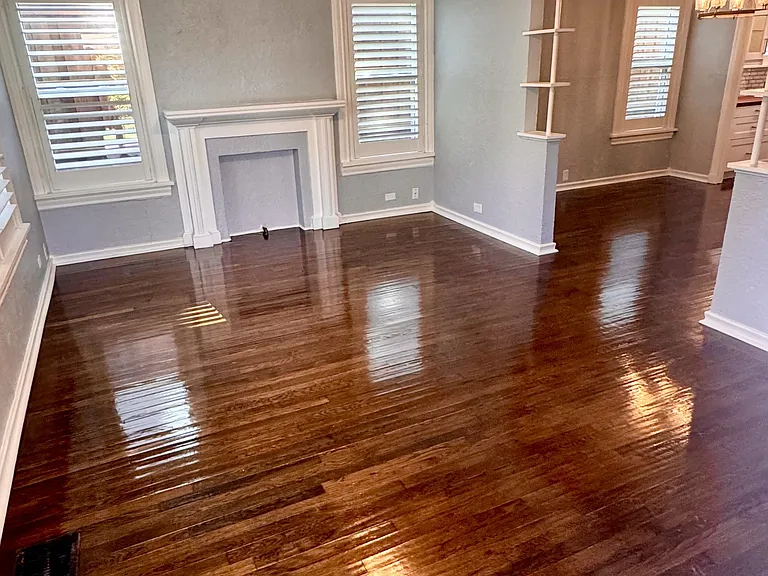 View from the living room, gorgeous hand scraped hardwood floors, custom wood plantation shutters, and the feaux fireplace.