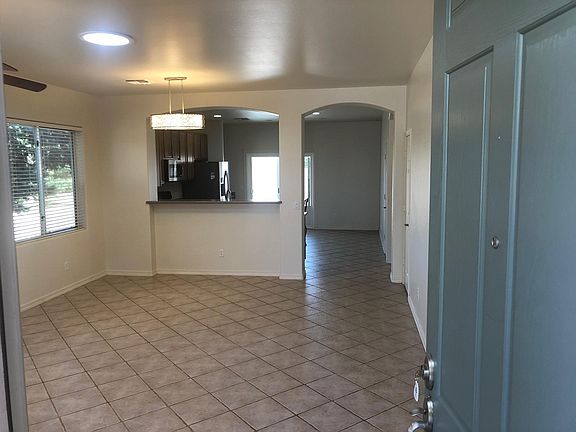 The entry door is 8 ft. tall with a Security Screen door. It opens to the living room with a dining area, and kitchen (open floorplan), with all tile flooring.