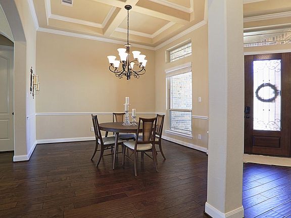 The Formal Dining room showcases coffered ceiling & gorgeous wood flooring