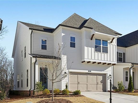 Modern farmhouse style home featuring a garage, concrete driveway, a shingled roof, board and batten