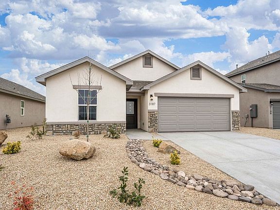 Single-story modern house with a two-car garage, stone accents, and a low-maintenance front yard fea