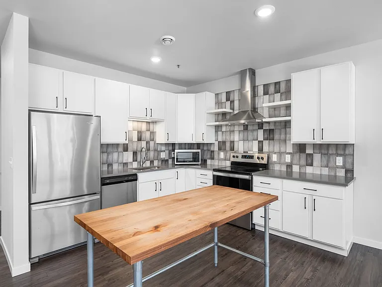 Modern kitchen with sleek stainless steel appliances, stylish tiled backsplash, and a spacious wooden island. Modern kitchen with sleek stainless steel appliances, stylish tiled backsplash, and a spacious wooden island.