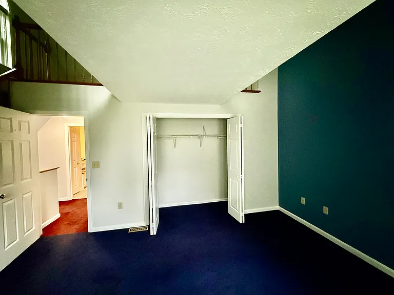 Primary bedroom, large closet, accent blue wall, lush carpet