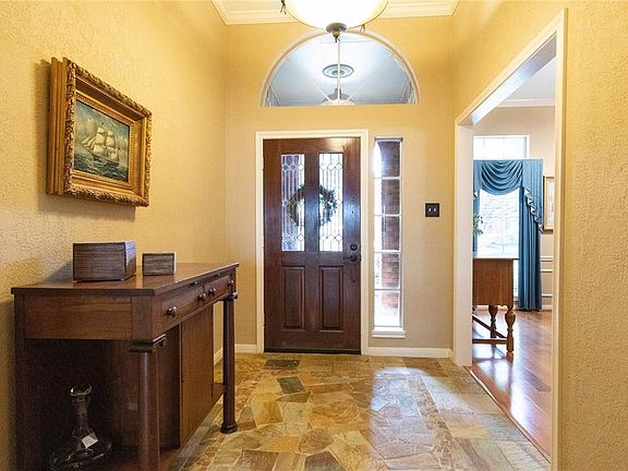 Inside you find this spacious entry with a high ceiling and tile floors.