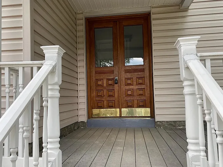 Welcoming front entrance featuring beautiful solid wood double doors and a covered porch.