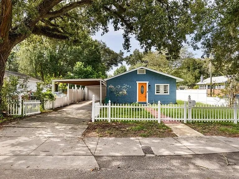 Front of home with fully fenced front yard.