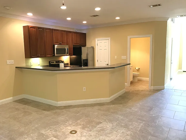 Living room with kitchen. This shows the pantry closet beside of the refrigerator and the half bathroom on this first floor of the townhome.