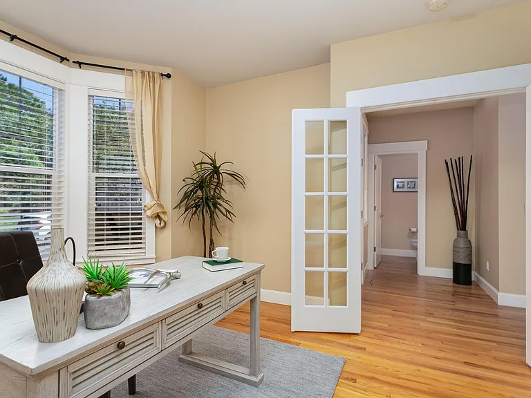 Bedroom or home office suite on main level with glass pane French doors, bay windows and walk-in closet.
