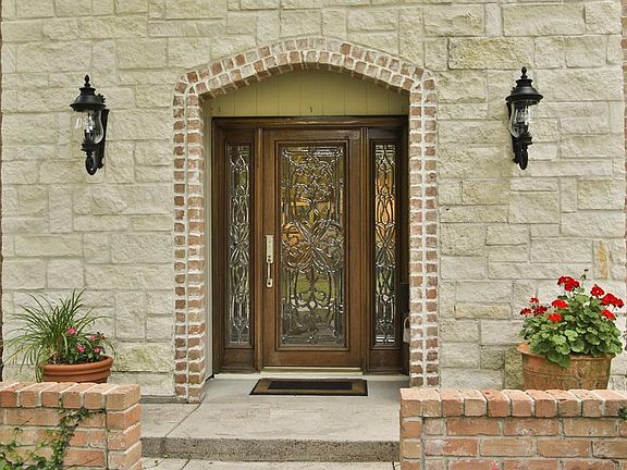As you approach the entry of the home, you will notice the limestone entry with decorative black lighting for accent as well as the beautiful glass door entry with complimentary side lights.