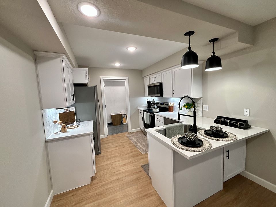 Kitchen featuring luxury vinyl plank, quartz countertops and stainless steel appliances. Laundry room attached.