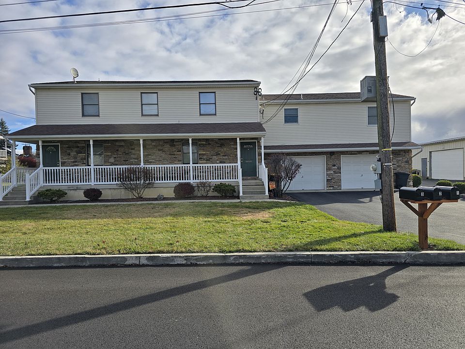 First floor apartment with front porch and one car detached garage.